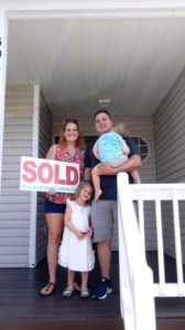 Erin and Shawn with "sold" sign.